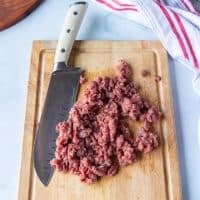 finely chopped, almost like coarse ground looking beef on the cutting board showing the correct texture