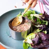 Spooning in the steak tartare mixture into the round mold and pressing the mixture well to hold the round shape