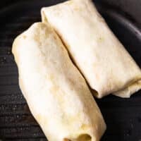 two tuna wraps folded and placed in a grill pan to press down