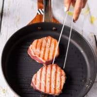 Perfect tuna steaks seared on one side, flipped to show the grill marks and continue cooking on the other side