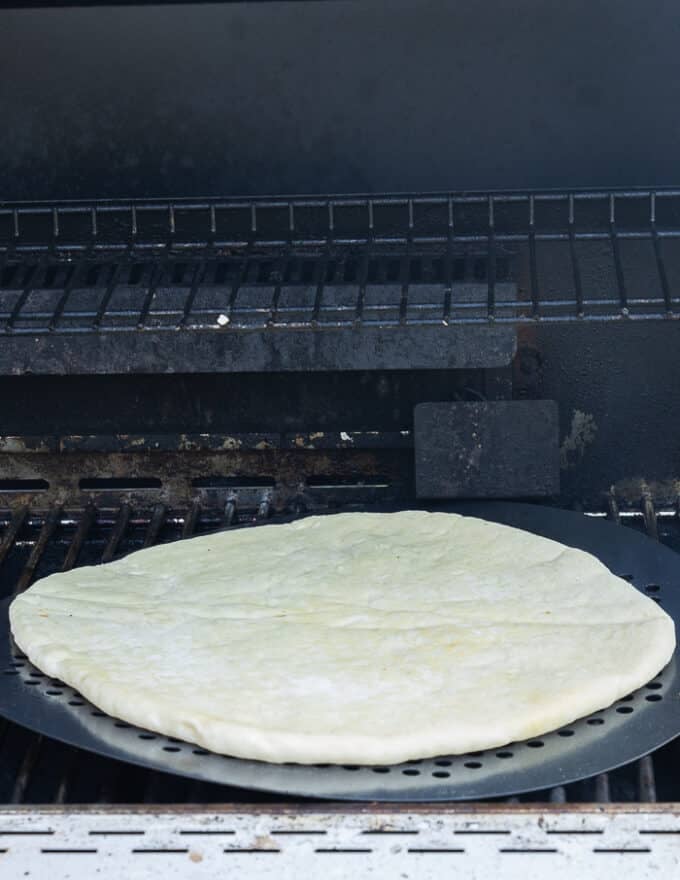pizza dough placed on the grill 