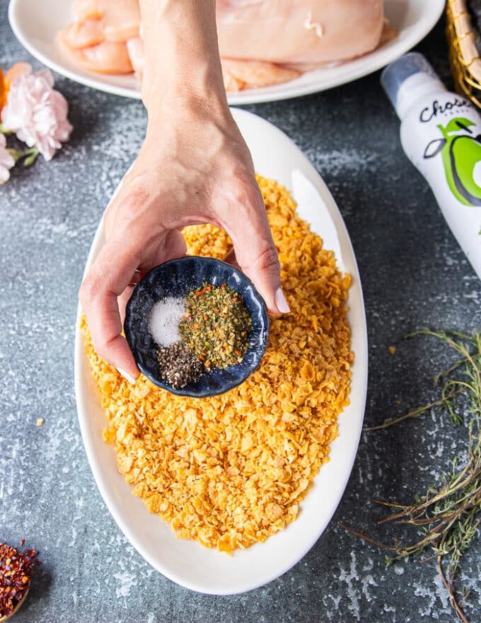 The cornflakes plate being seasoned withe the spice blend in a shallow plate to prepare the coating