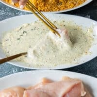 coating process of the hot honey chicken, one chicken tender dipped into the wet bowl
