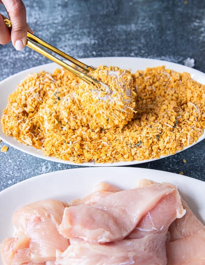 The chicken tender is then placed in the bowl of seasoned cornflakes for the final coating 
