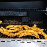 corn ribs cooking on the grill grates and charred