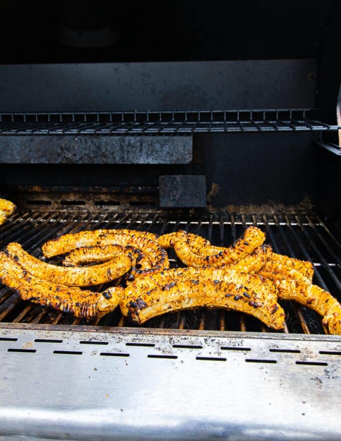 corn ribs cooking on the grill grates and charred 