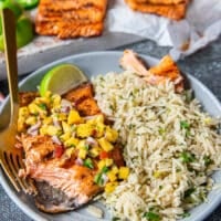 A fork cutting up the grilled trout showing how succulent and well grilled the fish is