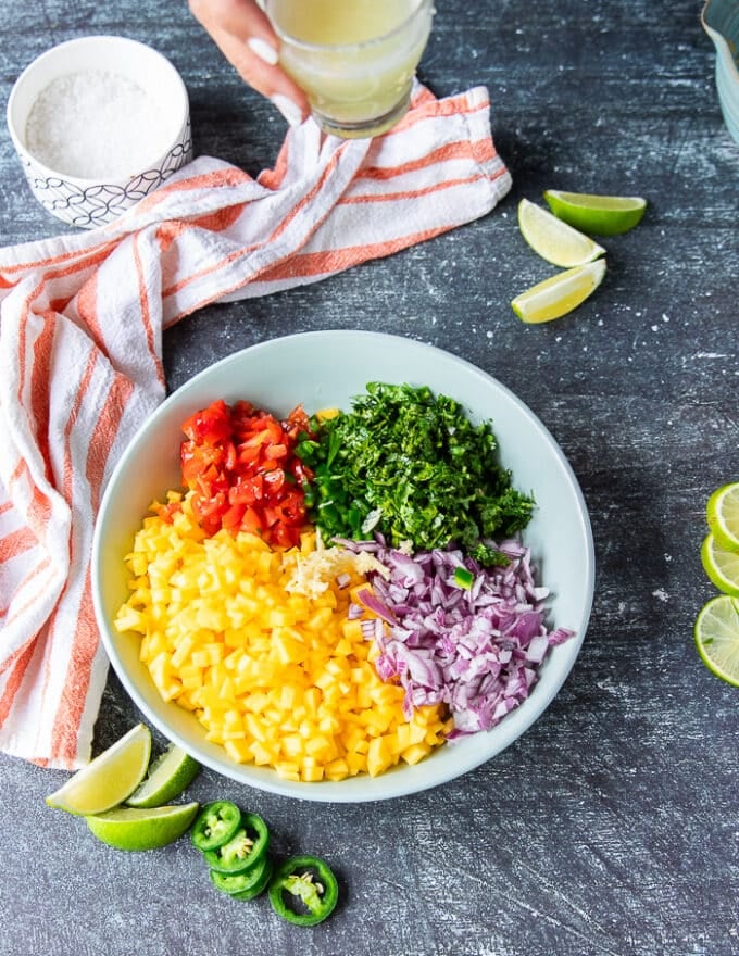 All ingredients of the mango pico de gallo added into a large shallow bowl together 