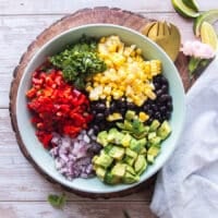 All the black bean salad ingredients are added on top of the salad dressing plate