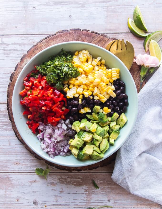 All the black bean salad ingredients are added on top of the salad dressing plate
