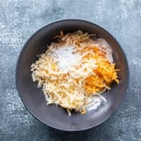 The shredded cheese in a bowl tossed in cornstarch separately.