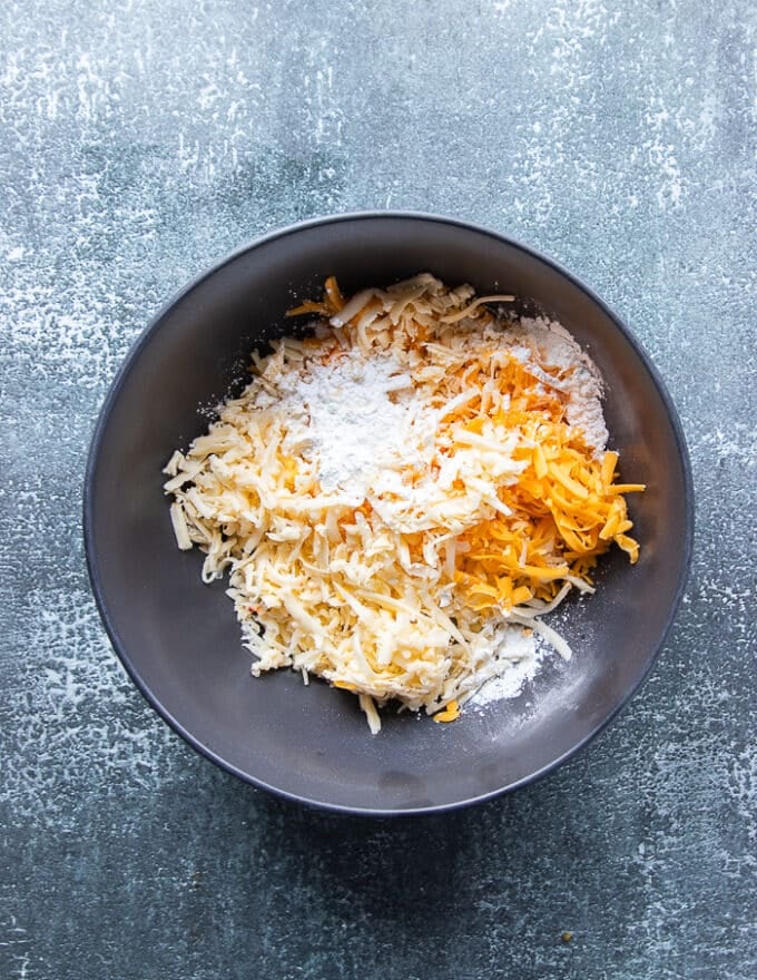 The shredded cheese in a bowl tossed in cornstarch separately.