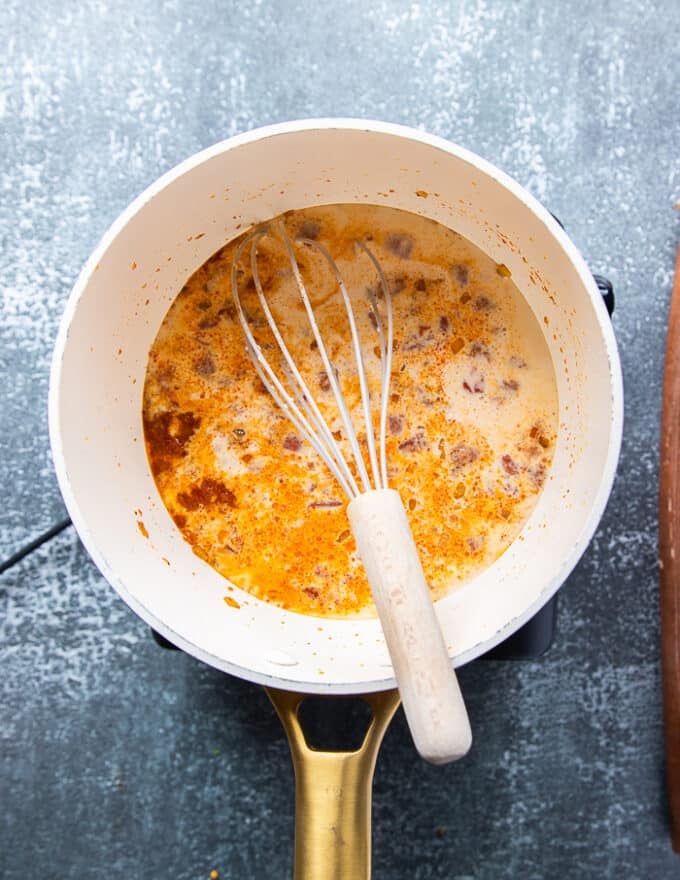 Milk is added to the pot for the queso recipe