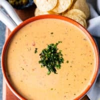 The queso sauce poured into a bowl and close up shot of the dip garnished with cilantro