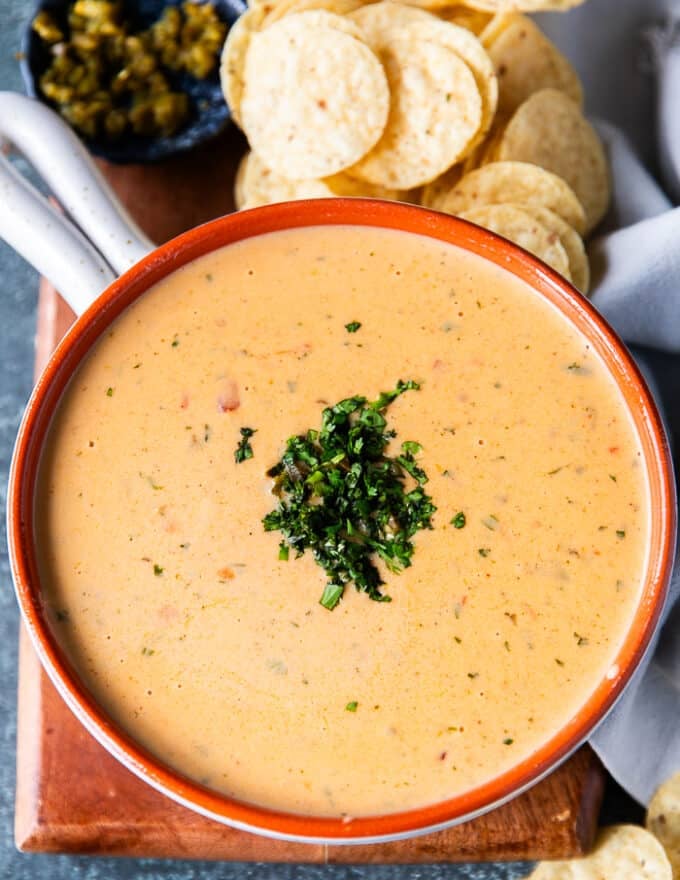 The queso sauce poured into a bowl and close up shot of the dip garnished with cilantro