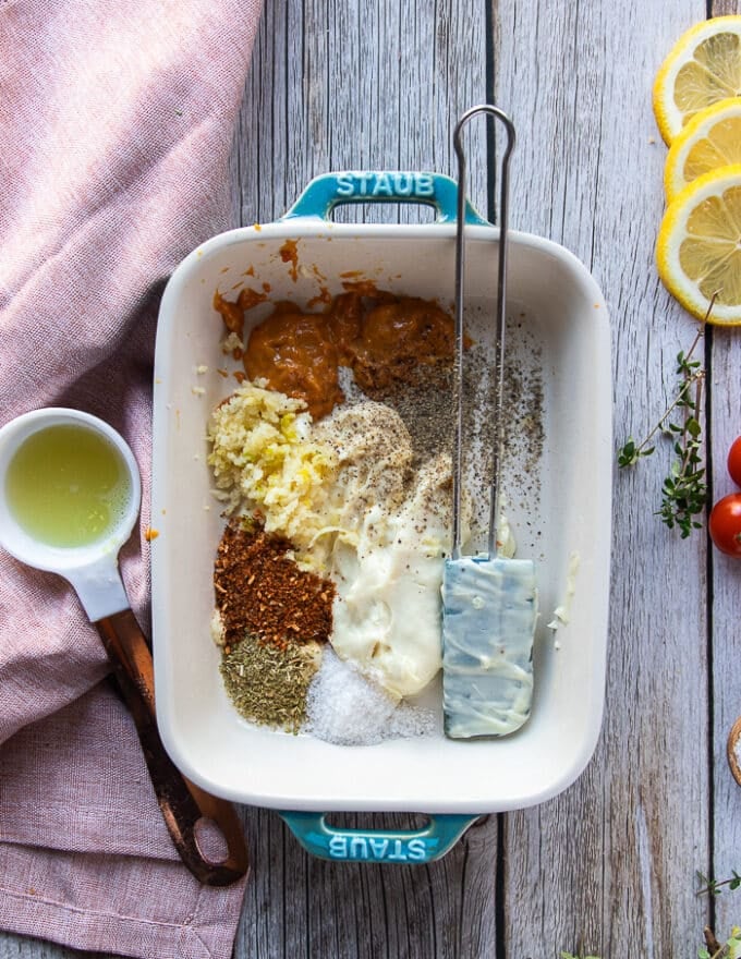 wet coating ingredients for the perch recipe including mayonnaise, lemon juice, fresh garlic minced, oregano, paprika in a shallos plate