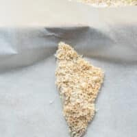 Fully coated perch fish placed on a parchment lined baking sheet