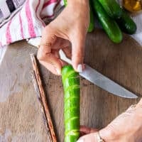 A hand showing how the cucumbers are ready cut up and spiralled