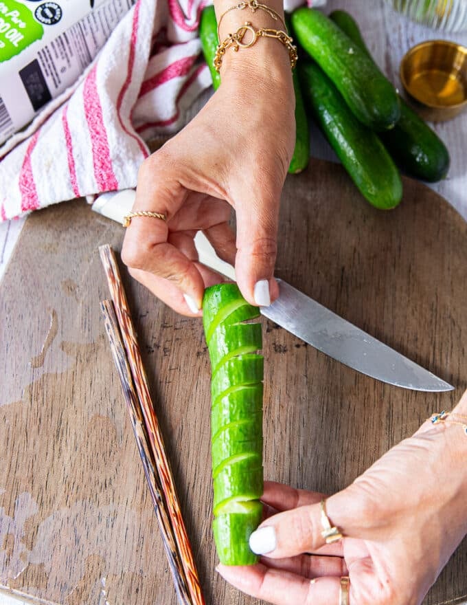 A hand showing how the cucumbers are ready cut up and spiralled 