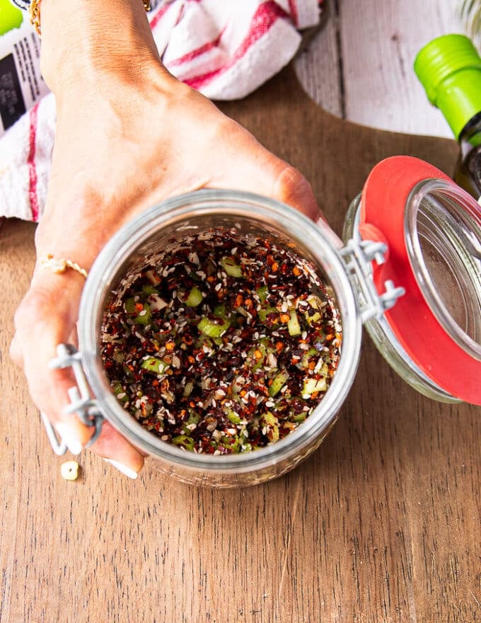 All chili oil ingreidnets are added into a wide mouth jar like salt, sugar, chilli flakes, ginger, garlic, scallions 