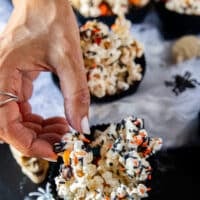 A hand grabbing the halloween popcorn showing close up of the texture