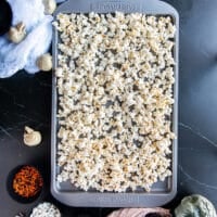 The popped popcorn spread in a baking sheet in a single layer