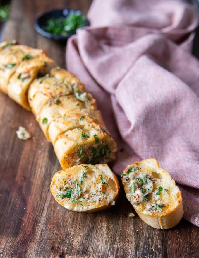 perfect air fryer garlic bread removed form the air fryer into a board and the slices slightly separated by pulling apart 