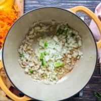 A large pot with the onions sautéing in butter