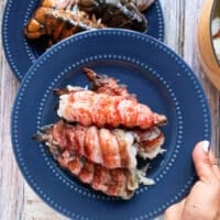 A hand holding a plate of lobster meat ready to butter poach