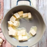 Butter cubes are added to a skillet and beginning to melt softly