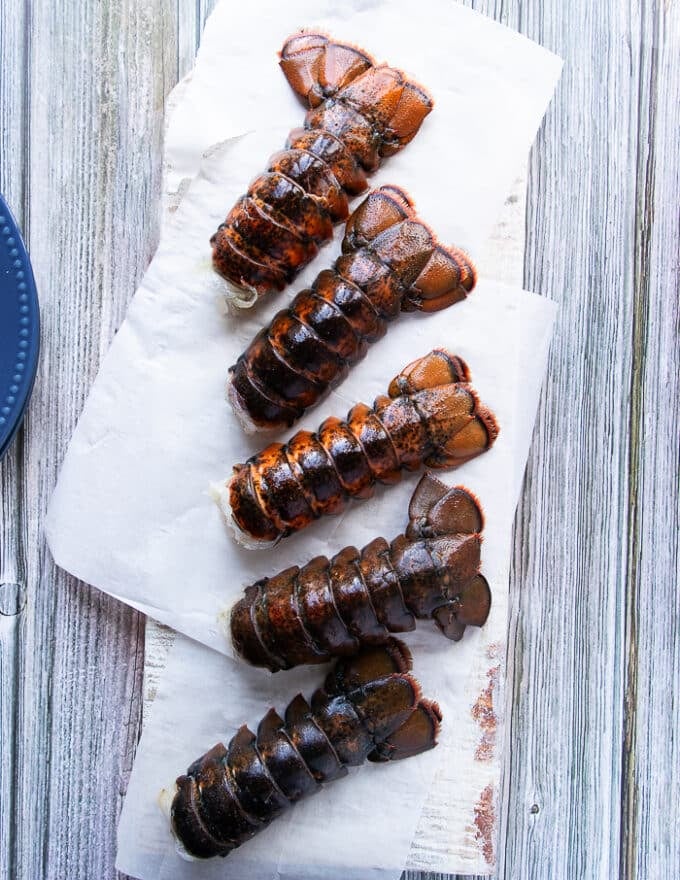 A board with parchment paper and some lobster on top