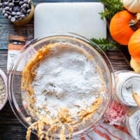 flour, baking soda and salt are added to the bowl to pumpkin oatmeal cookie batter