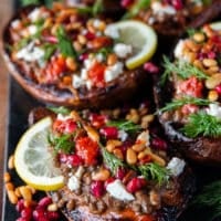 close up of one stuffed sweet potato showing the texture of the roasted sweet potatoes so soft and loaded with filling like lentils, pomegranates , hot sauce, fresh herbs, feta cheese
