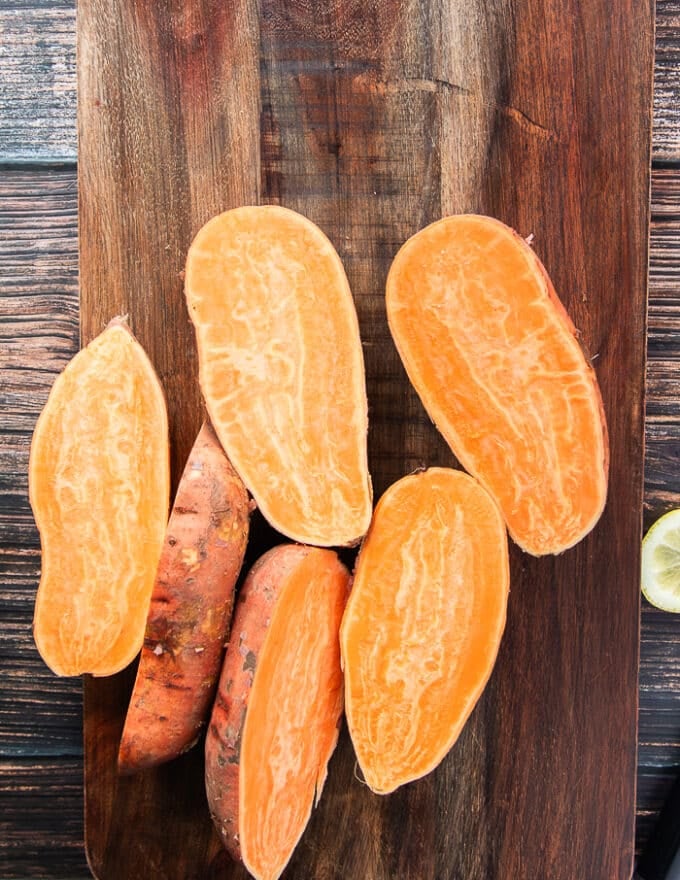 sweet potatoes cut in half on a wooden board 