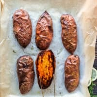 sweet potatoes perfectly roasted and out of the oven, one half is flipped the other side to show the caramelized top and how perfectly cooked it is