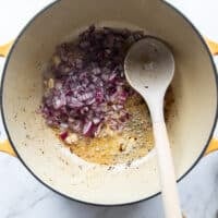 Onions are added into the same pot to start making the sauce