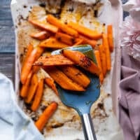 A spoon showing the carrots ready and glazed close up to the camera