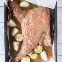 The stock is poured around the lamb shoulder and ready to roast