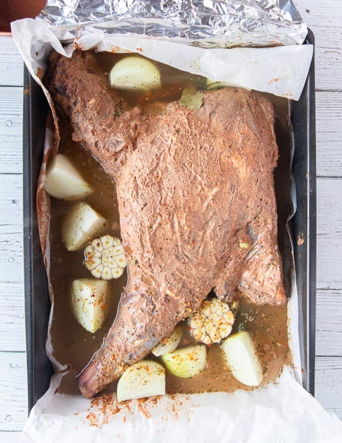 The stock is poured around the lamb shoulder and ready to roast 