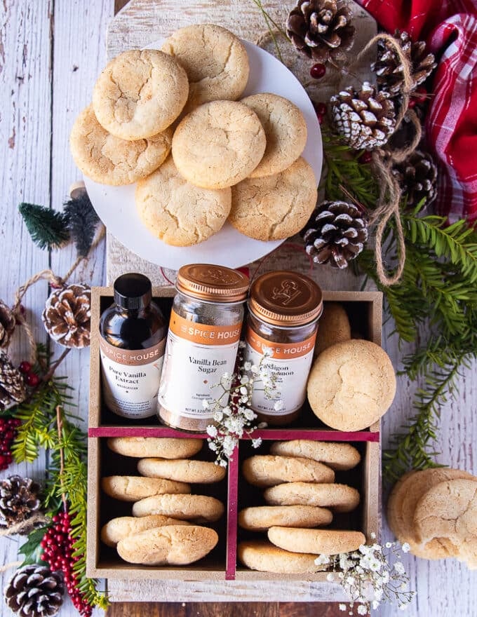 All the bakes sugar cookies on a board, some served on a plate and some arranged in a cookie box for gifting. 