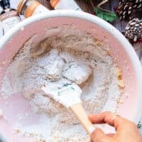 A spatula is used to blend in the dry ingredients into the butter mixture to make the sugar cookie dough without over mixing