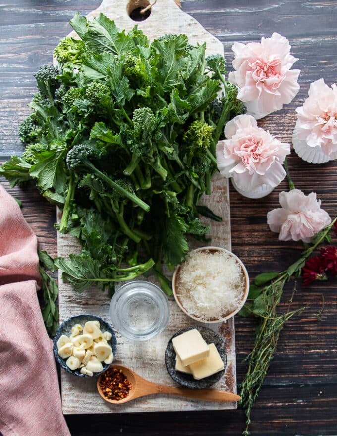 Ingredients needed to cook broccoli rabe including olive oil or butter, garlic, the broccoli rabe and some parmesan cheese