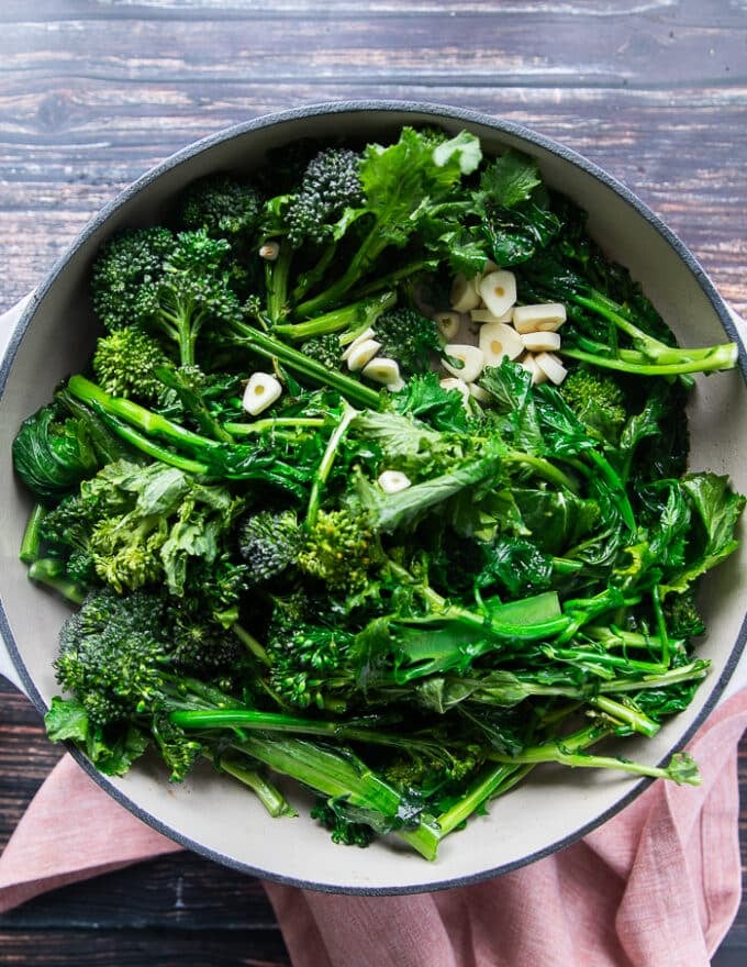 Broccoli Rabe and garlic slices in a deep oval skillet with butter or olive oil, sautéed