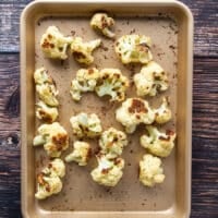 the cauliflower florets in a baking sheet, roasted and golden, ready to use