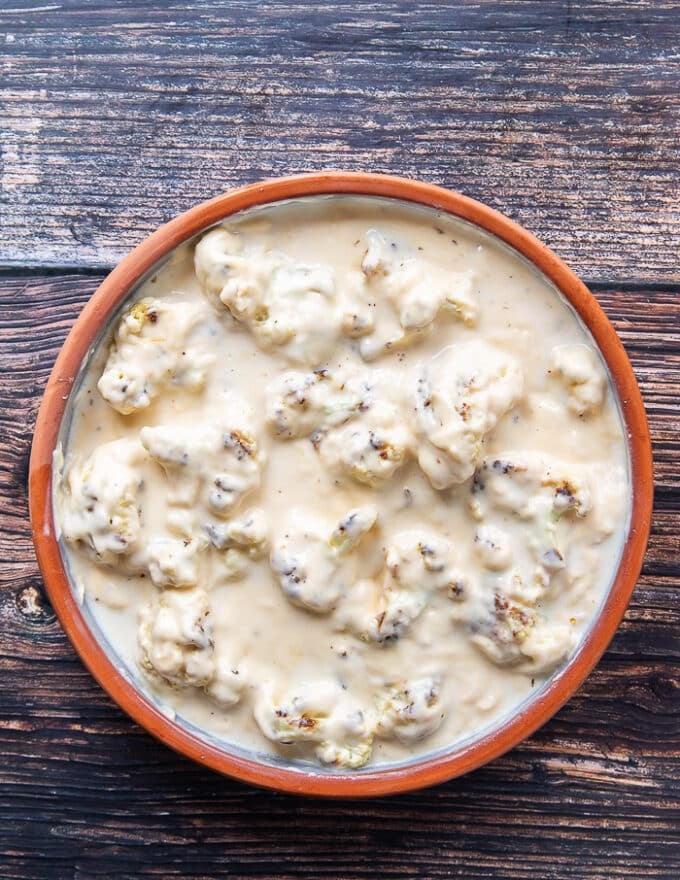 The sauce is spread right over the cauliflower florets in the casserole dish 