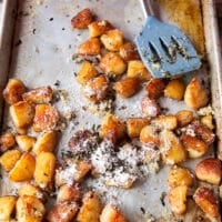 rosemary, minced garlic and parmesan are added to the ready potatoes in the baking sheet for seasoning and flavoring them