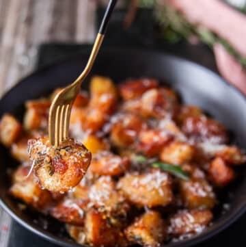 a fork showing close up of one crispy potato and how crisp and golden it is
