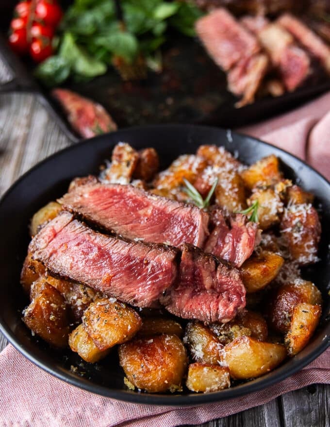 Rib eye steak slices served with the crispy potatoes 