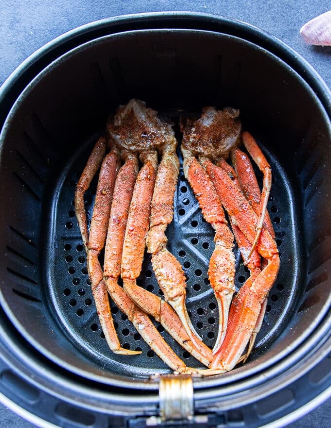seasoned crab legs in a large air fryer basket