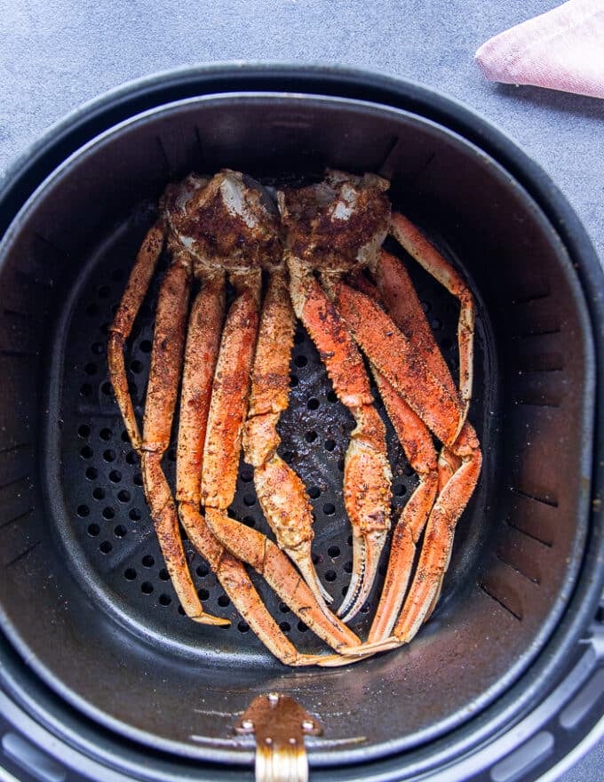 Air fried crab legs ready to eat in an air fryer basket